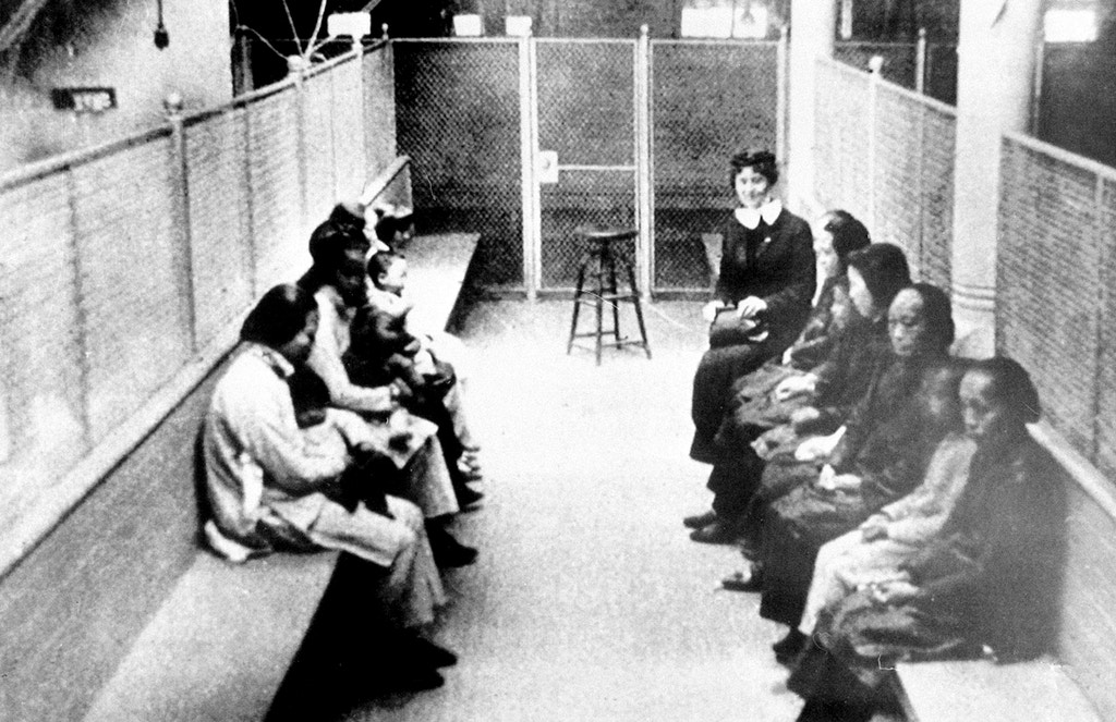 A group of Chinese and Japanese women and children wait to be processed as they are held in a wire mesh enclosure at the Angel Island Internment barracks in San Francisco Bay in the late 1920s.  The Angel Island Immigration Station processed one million immigrants from 1910 to 1940, mostly from China and Japan.  (AP Photo)