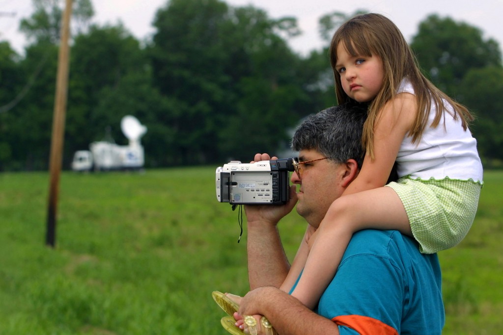  Dean Spiegel from Indianapolis, Indiana carries his 4-year-old daughter Sophia on his shoulders June 9, 2001 as he videotapes activities near the entrance to the grounds of the U.S. Federal Prison in Terre Haute, Indiana. Convicted Oklahoma City bomber Timothy McVeigh is scheduled to be executed at the prison on June 11, 2001. (Photo by Tim Boyle/Getty Images)
