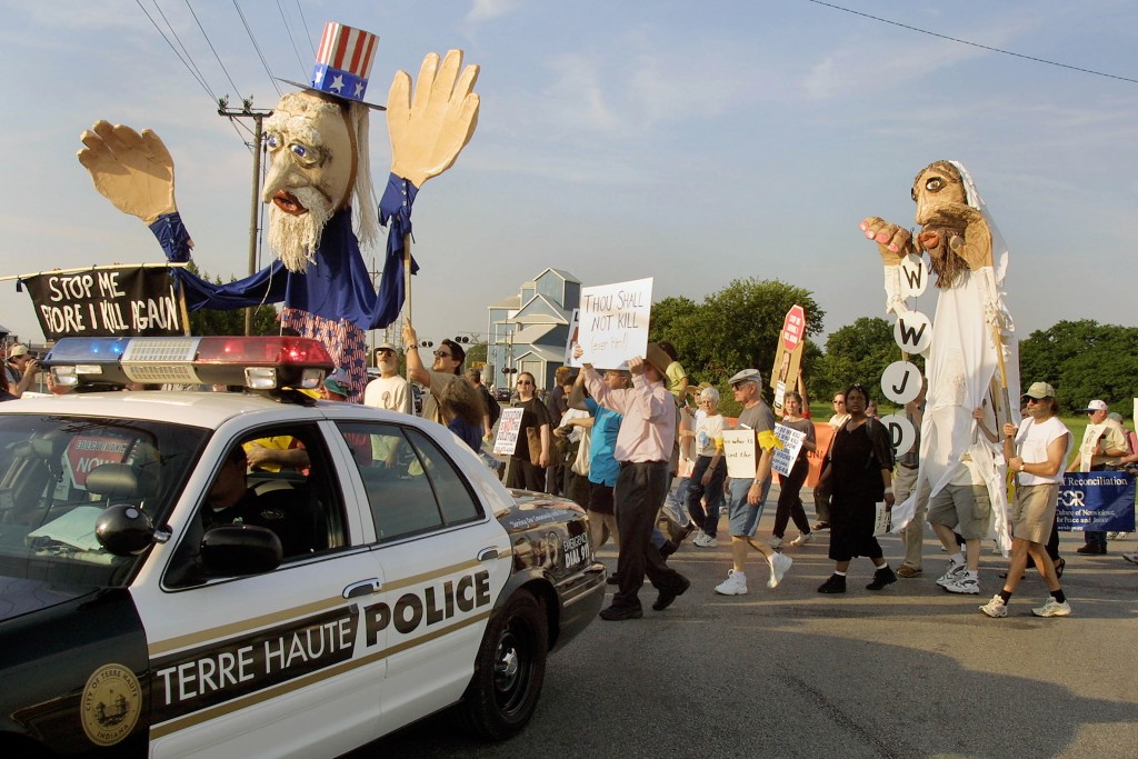 390397 03: A Terre Haute police car precedes anti-death penalty demonstrators June 10, 2001 during a march along a street from St. Margaret Mary Parish in Terre Haute, Indiana. Convicted Oklahoma City bomber Timothy McVeigh is scheduled to be executed at the federal prison in Terre Haute on June 11, 2001. (Photo by Tim Boyle/Getty Images)