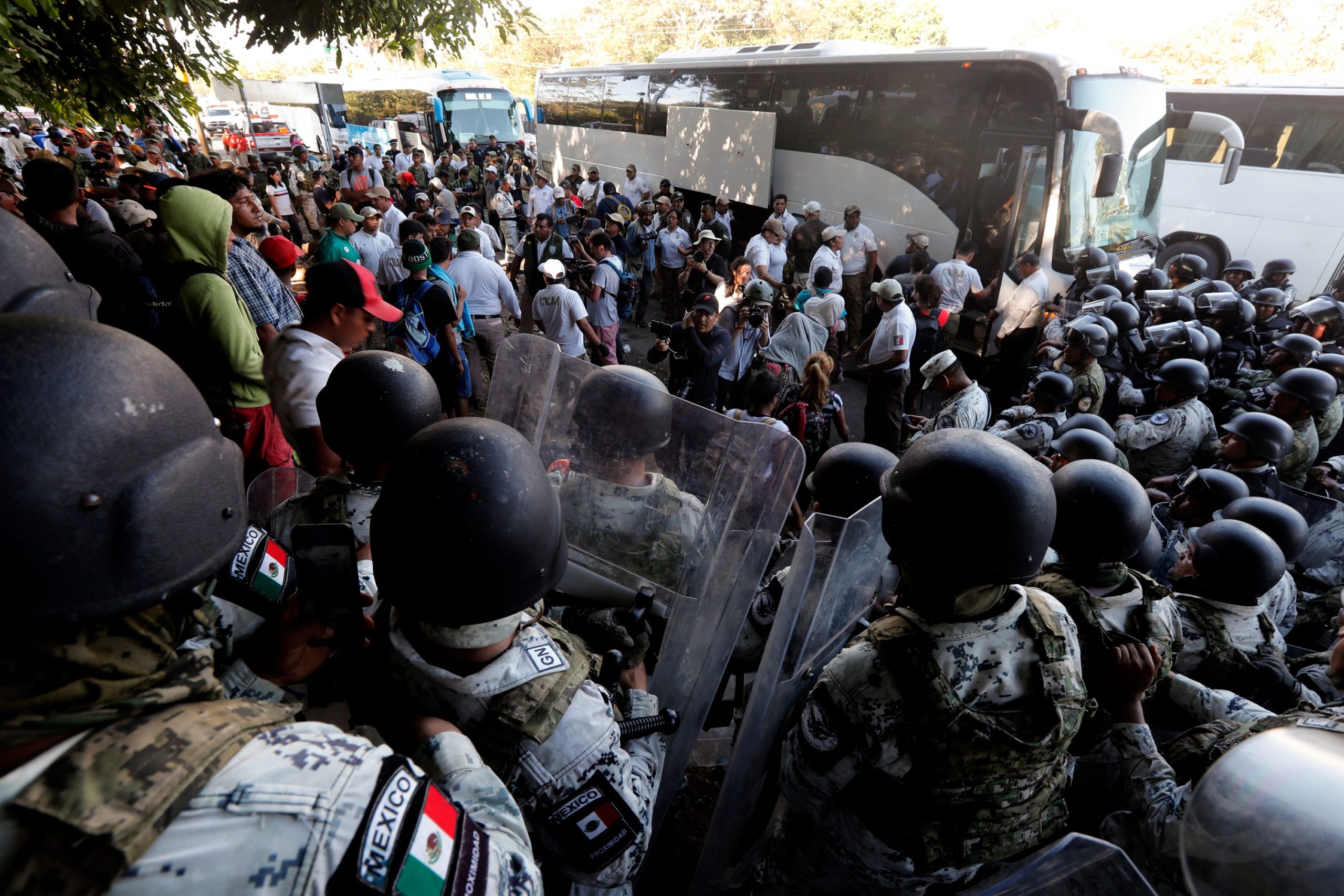 Migrants board buses after their passage was blocked by Mexican National Guards near Tapachula, Mexico, Thursday, Jan. 23, 2020. Hundreds of Central American migrants crossed the Suchiate River into Mexico from Guatemala Thursday after a days-long standoff with security forces. (AP Photo/Marco Ugarte)