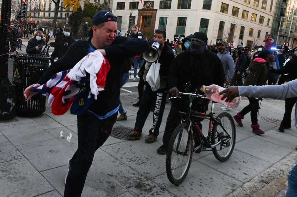 A supporter of US President Donald Trump is attacked by anti-Trump demonstrators in Black Lives Matter Plaza in Washington, DC on November 14, 2020. (Photo by Roberto SCHMIDT / AFP) (Photo by ROBERTO SCHMIDT/AFP via Getty Images)
