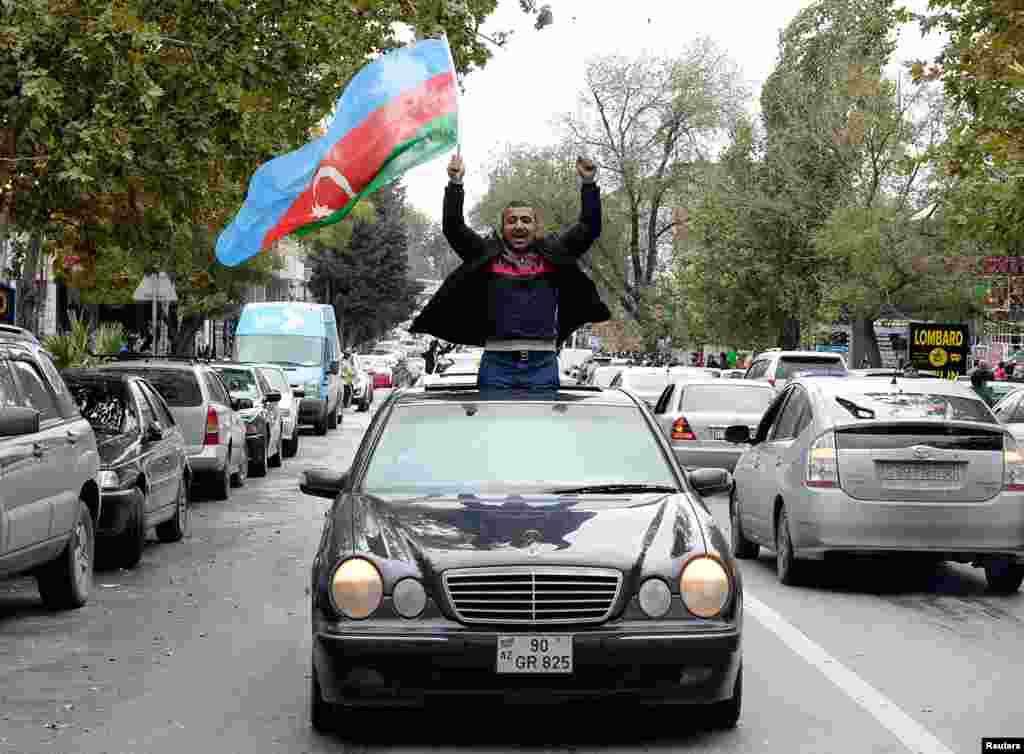 A man in Baku joins crowds celebrating in the Azerbaijani capital after President Ilham Aliyev claimed on November 8 that his forces had captured the city of Shushi/Susa.&nbsp;