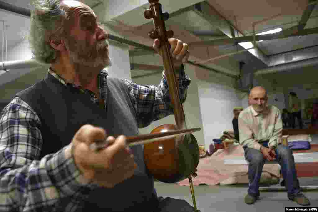 Armenian musician Hakob Khalatian plays his kamancha string instrument for in a bomb shelter in Stepanakert on November 5.&nbsp;