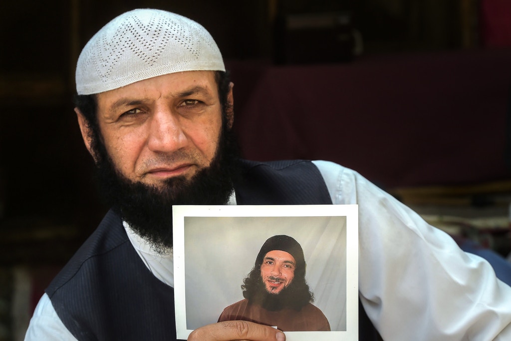 In this picture taken on September 25, 2020, Afghan refugee Roman Khan displays a photograph of his brother Asadullah Haroon, who is detained in Guantanamo Bay detention camp, during an interview with AFP in Shamshatu refugee camp near Pakistan's northwestern city of Peshawar. - Hundreds of prisoners including senior Taliban leaders have been released from the notorious US military detention centre, but Asadullah Haroon, who has never been charged with a crime, remains. (Photo by Abdul MAJEED / AFP) / To go with 'AFGHANISTAN-GUANTANAMO-PRISONERS', FOCUS by David Stout and Sajjad Tarakzai (Photo by ABDUL MAJEED/AFP via Getty Images)