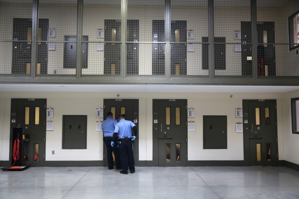 Guards prepare to escort an immigrant detainee from his 'segregation cell' back into the general population at the Adelanto Detention Facility on November 15, 2013 in Adelanto, California.