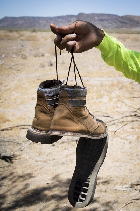 One of the soles of Gilberto Mateos's shoes hangs as the glue melted and came apart during a mission with Aguílas del Desierto search and rescue crew on May 27, 2017 in the Cabeza Prieta wilderness near Ajo, Arizona. (Photo by Caitlin O'Hara/Getty Images)