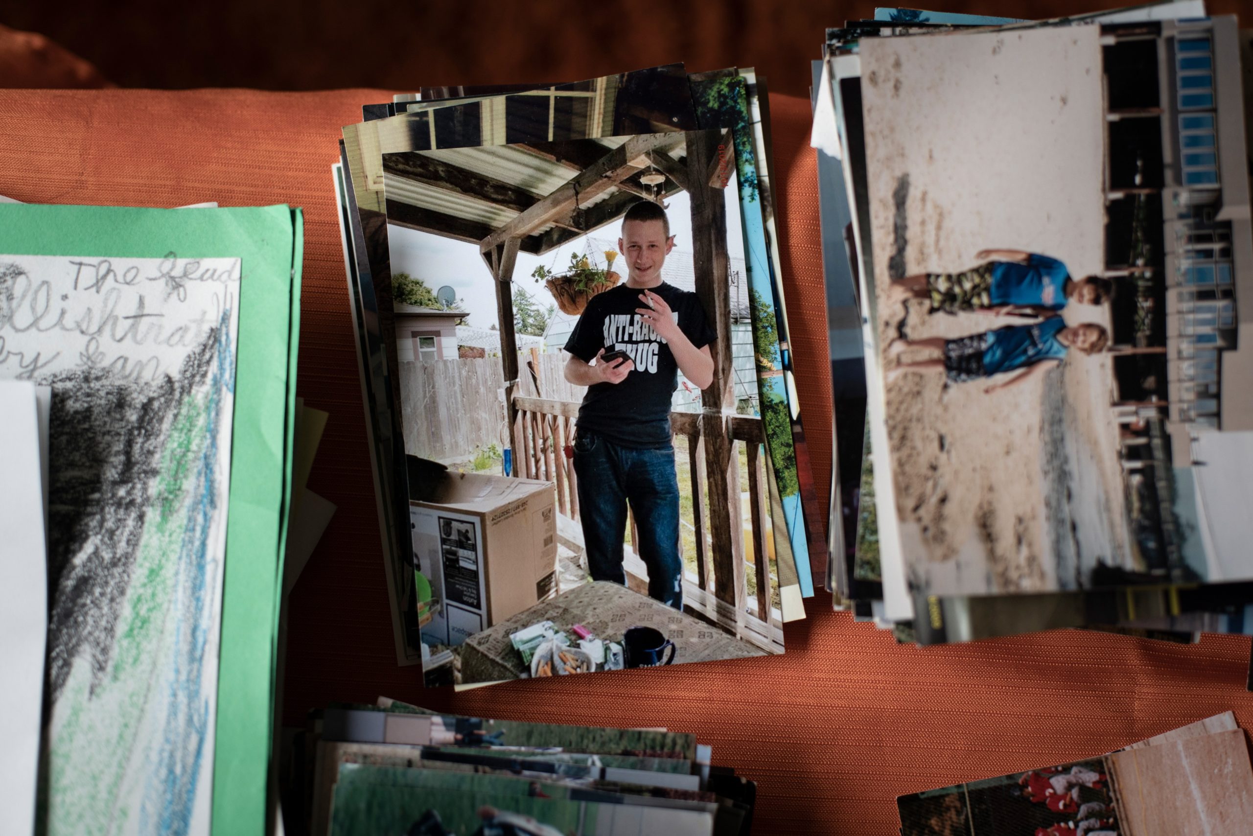 Photos and mementoes of Sean Kealiher, a Portland activist killed in 2019, are seen in his mother's home in Portland, Oregon, on January 30, 2021. In the center photo, Sean is wearing a shirt which reads, "Anti-Racist Thug," and on the right is a photo of him and his brother on an Oregon beach. Brooke Herbert for The Intercept