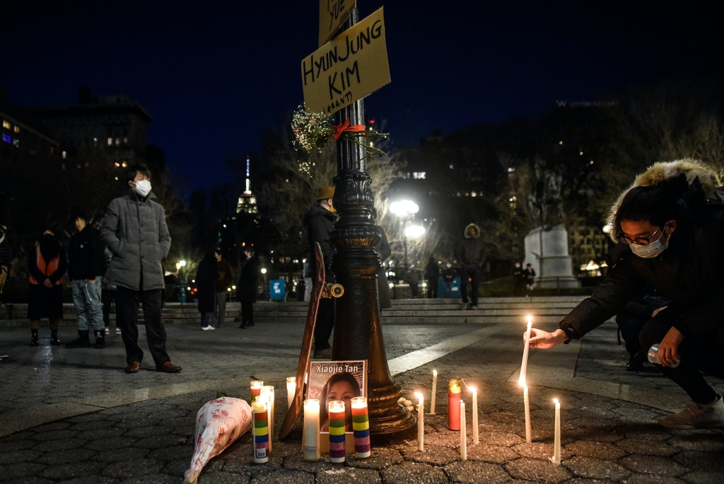 A person lights candles during a peace vigil to honor victims of attacks on Asians on March 19, 2021 in Union Square Park in New York City. 